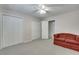 Bedroom featuring carpeting, closets, a ceiling fan, and cozy red sofa at 3550 Gravitt Rd, Cumming, GA 30040