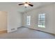 Bright bedroom featuring neutral carpet, two windows overlooking the yard, and a ceiling fan at 3550 Gravitt Rd, Cumming, GA 30040