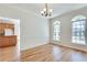 Bright dining room featuring hardwood floors, wainscoting, and arched windows with views of the backyard at 3550 Gravitt Rd, Cumming, GA 30040