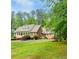 Beautiful brick home with lush landscaping and a well manicured lawn on a sunny day at 3550 Gravitt Rd, Cumming, GA 30040