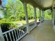 Charming front porch with white columns and railing, offering a serene view of the landscaped yard at 3550 Gravitt Rd, Cumming, GA 30040