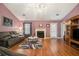 Cozy living room with hardwood floors, a decorative fireplace, and comfortable seating creates a welcoming ambiance at 5936 Old Wellborn Trce, Lithonia, GA 30058
