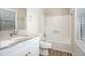 Bathroom featuring a granite-topped vanity, framed mirror, and a shower-tub combination with updated fixtures at 3807 Memorial Nw Pkwy, Kennesaw, GA 30152