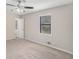 Spacious bedroom featuring neutral paint, carpet, a ceiling fan, and natural light from the window at 3807 Memorial Nw Pkwy, Kennesaw, GA 30152