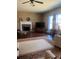 Sunlit living room with a fireplace and a ceiling fan above wood floors and a colorful rug at 398 Kyles Cir, Hiram, GA 30141