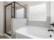 Luxurious bathroom featuring a soaking tub, a tiled shower with black trim, and a frosted window for privacy at 712 Shetland Trl, Cartersville, GA 30121