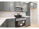 Close-up view of stainless steel microwave and range with gray cabinets and white countertops at 712 Shetland Trl, Cartersville, GA 30121