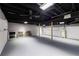Spacious unfinished basement with painted concrete floor and open ceiling with fan and black rafters at 2852 Crabapple Lane, Dacula, GA 30019