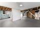 Unfinished basement with exposed ceiling, painted floor, and natural light coming through a window at 2852 Crabapple Lane, Dacula, GA 30019