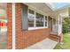 Close-up of home's brick facade, showcasing the shuttered windows and neat, tidy front porch at 2852 Crabapple Lane, Dacula, GA 30019
