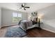 Cozy bedroom with wood floors, neutral tones, a ceiling fan, and a window with backyard views at 4441 Langdon Se Walk, Smyrna, GA 30080