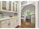 Butler pantry connecting dining room and living room with white cabinets and countertop at 4441 Langdon Se Walk, Smyrna, GA 30080