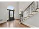 Grand foyer featuring an elegant staircase, hardwood floors, and a beautifully designed glass front door at 4441 Langdon Se Walk, Smyrna, GA 30080