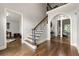Elegant foyer showcasing hardwood floors, graceful staircase, and arched doorway, enhancing the home's charm at 4441 Langdon Se Walk, Smyrna, GA 30080