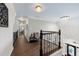 Upstairs hallway with wood floors, decorative railing, and a chandelier over the home's entryway at 4441 Langdon Se Walk, Smyrna, GA 30080