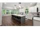 Expansive kitchen featuring an island with seating, white cabinets, pendant lighting, and large picture windows at 4441 Langdon Se Walk, Smyrna, GA 30080