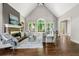 Bright, airy living room with stone fireplace, soaring ceilings, and large windows overlooking lush greenery at 4441 Langdon Se Walk, Smyrna, GA 30080