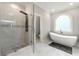 Modern bathroom with stand up shower and a freestanding tub by a frosted window at 4441 Langdon Se Walk, Smyrna, GA 30080