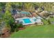 Aerial view of a community pool, tennis courts, and playground surrounded by lush greenery at 1025 Abingdon Ln, Johns Creek, GA 30022