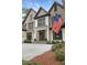 Elegant two-story home with a well-manicured lawn and an American flag, showcasing classic architectural details at 1025 Abingdon Ln, Johns Creek, GA 30022
