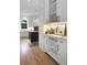 Modern kitchen with white cabinets, hardwood floors, and stainless steel appliances at 1025 Abingdon Ln, Johns Creek, GA 30022