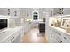 Modern kitchen with white cabinets, hardwood floors, and stainless steel appliances at 1025 Abingdon Ln, Johns Creek, GA 30022