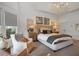 Bright and airy main bedroom with a large window, chandelier, upholstered furniture, and ensuite bathroom access at 1025 Abingdon Ln, Johns Creek, GA 30022