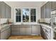 This updated kitchen features gray cabinets, granite countertops, and stainless steel appliances at 295 Pebble Trl, Alpharetta, GA 30009