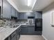 Modern kitchen with sleek gray cabinets, granite countertops, stylish backsplash, and stainless steel appliances at 2965 Pharr Court South Nw # 102, Atlanta, GA 30305