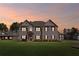 Beautiful two-story home with a gray brick facade set against a picturesque sunset backdrop at 701 Cupcake Ct, Mcdonough, GA 30252
