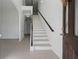 Bright and spacious foyer featuring a staircase with a wooden handrail and elegant trim at 701 Cupcake Ct, Mcdonough, GA 30252