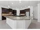 Stunning kitchen boasting a large granite island, dark cabinets, stainless steel appliances, and pendant lighting at 701 Cupcake Ct, Mcdonough, GA 30252