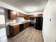 Kitchen featuring sleek, black appliances, wooden cabinetry and modern floors at 925 Seasons Pkwy, Norcross, GA 30093