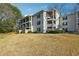 Low angle view of a three-story apartment complex with multiple balconies and light gray facade at 1150 Collier Nw Rd # J11, Atlanta, GA 30318