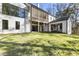 Exterior rear view of the home with a large grassy yard, patio area, and large windows offering ample natural light at 128 Owens Mill Pl, Canton, GA 30115