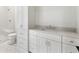 Modern white bathroom with a glass-enclosed shower, patterned tile floor, and updated vanity with white countertop at 128 Owens Mill Pl, Canton, GA 30115