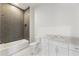 Modern bathroom with gray herringbone tiled shower, mosaic floors, and white vanity with marble countertop at 128 Owens Mill Pl, Canton, GA 30115