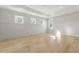 Spacious bedroom featuring light hardwood floors, a tray ceiling, and abundant natural light from the large windows at 128 Owens Mill Pl, Canton, GA 30115