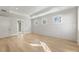 A well-lit bedroom highlighting stylish wall paneling, light hardwood floors, tray ceiling, and natural light at 128 Owens Mill Pl, Canton, GA 30115