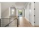 Upstairs hallway with hardwood floors, natural light, and black metal railings and doors at 128 Owens Mill Pl, Canton, GA 30115