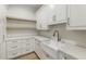 Bright kitchen features white cabinetry, farmhouse sink, marble countertops, and wood open shelving at 128 Owens Mill Pl, Canton, GA 30115
