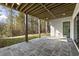 Covered patio with bluestone flooring, an exposed beam ceiling, and views of the wooded backyard at 128 Owens Mill Pl, Canton, GA 30115