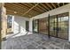 Covered patio with slate flooring, an exposed beam ceiling, and black framed windows leading into the home at 128 Owens Mill Pl, Canton, GA 30115