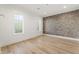 Empty room with hardwood floors, trim work, and a brick accent wall at 128 Owens Mill Pl, Canton, GA 30115