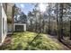 Side view of the home, showing the garage, backyard, and adjacent wooded area at 128 Owens Mill Pl, Canton, GA 30115