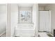 Bright bathroom featuring a soaking tub with shower and a window for natural light at 2248 Newbury Oaks Dr, Lawrenceville, GA 30044