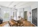 Dining room featuring a wooden table, bench seating, modern light fixture, and abundant natural light at 2248 Newbury Oaks Dr, Lawrenceville, GA 30044