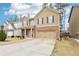 Two-story home boasts a brick-accented facade, neutral siding, a well-manicured front yard, and a large driveway at 2248 Newbury Oaks Dr, Lawrenceville, GA 30044