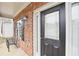 Close-up of a welcoming front door with sidelight, complemented by brick accents and outdoor seating at 2248 Newbury Oaks Dr, Lawrenceville, GA 30044