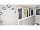 Hallway featuring a white banister, a collection of round mirrors, and black paneled doors at 2248 Newbury Oaks Dr, Lawrenceville, GA 30044